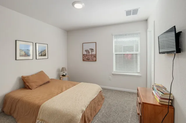 a bedroom with a bed and a window