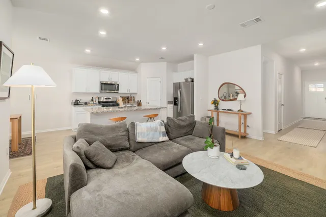 a living room with furniture and a wooden floor