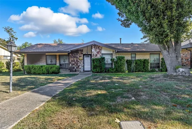 a front view of a house with yard and green space