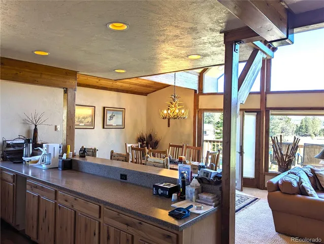 a bedroom with a bed a chandelier and a dresser next to a window