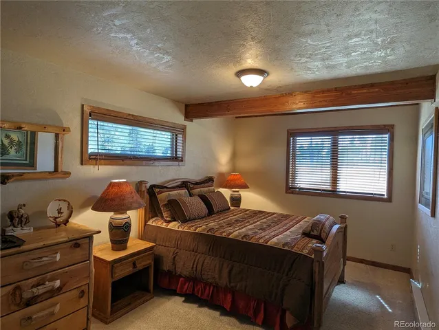 a large bedroom with a bed and wooden floor