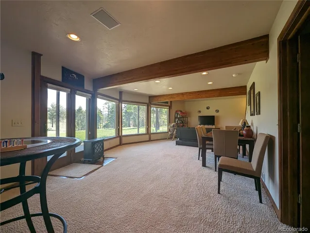 a view of an empty room with furniture and a window