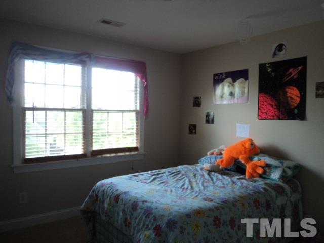 1108 Coram Fields Road Wake Forest, NC 27587 - Photo 16 of 24 a bedroom with a bed next to a window