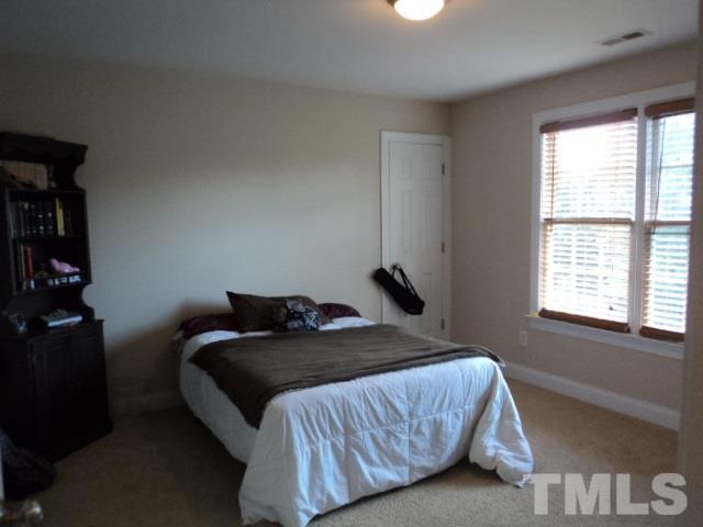 1108 Coram Fields Road Wake Forest, NC 27587 - Photo 19 of 24 a bedroom with a bed and a window