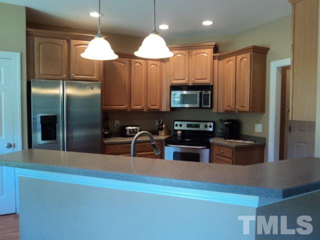 1108 Coram Fields Road Wake Forest, NC 27587 - Photo 7 of 24 a kitchen with stainless steel appliances granite countertop a refrigerator a stove a sink and a center island