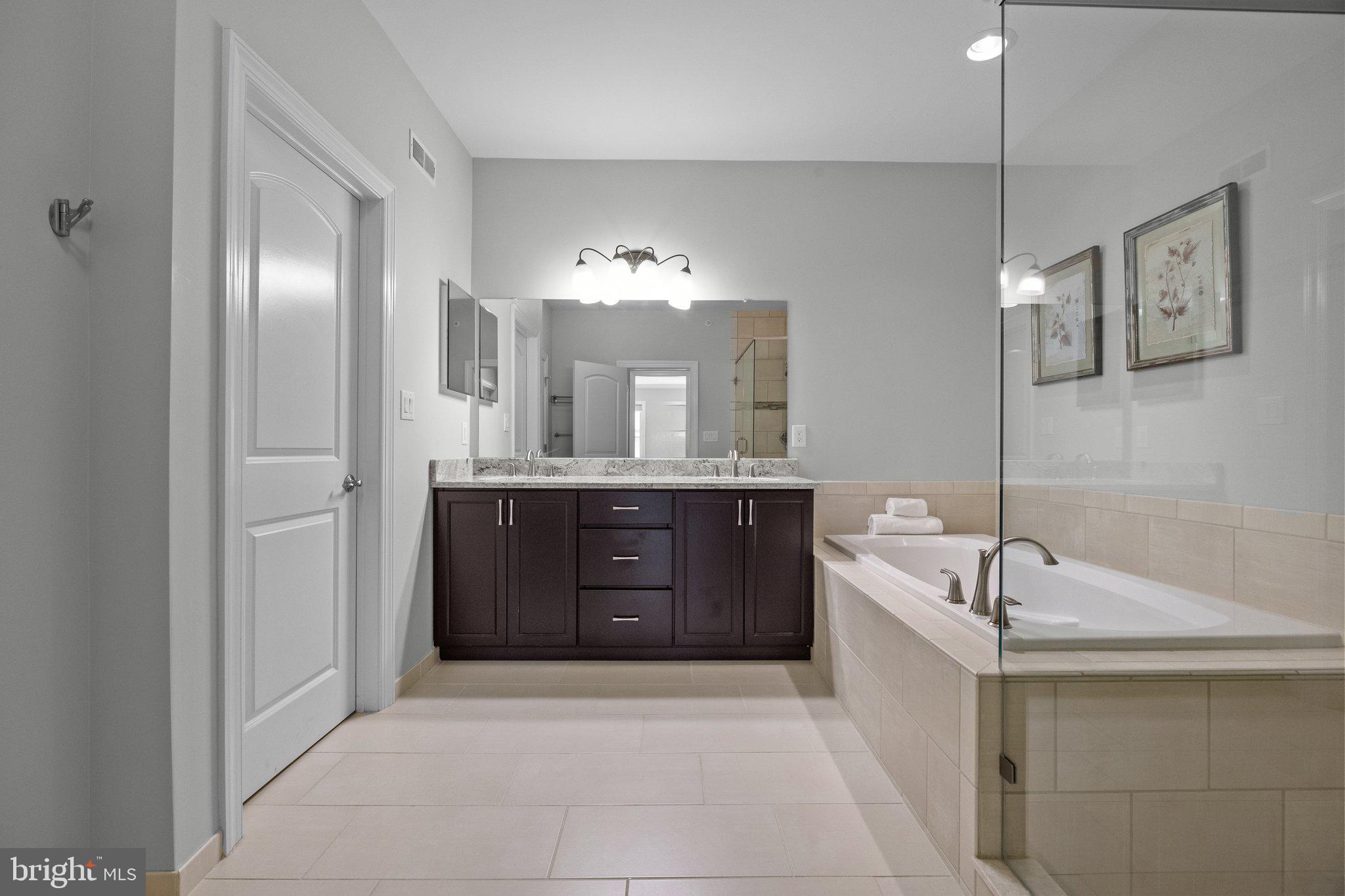 23 David Drive Newtown, PA 18940 - Photo 29 of 44 a spacious bathroom with a granite countertop sink a mirror and a bathtub