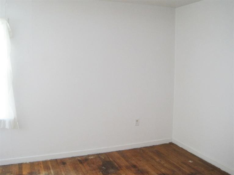 1003 16th Street Ralls, TX 79357 - Photo 3 of 9 a view of a small space with wooden floor and a window