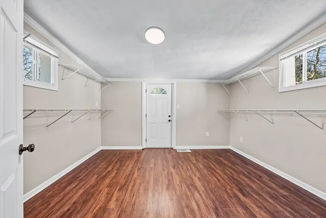 a view of a room with wooden floors and white walls