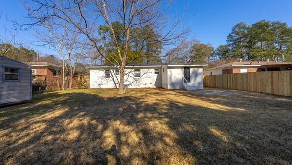 a view of a yard with wooden fence