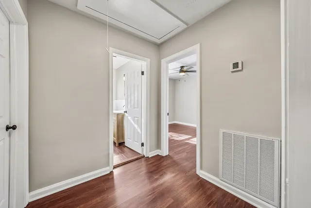 a view of a hallway with wooden floor