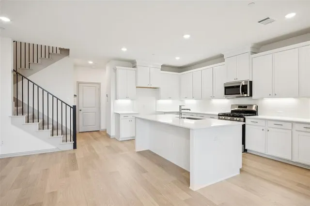 a view of kitchen with granite countertop a white stove top oven and white cabinets