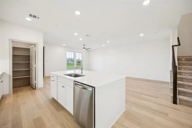 a kitchen with granite countertop a sink a stove oven and white cabinets