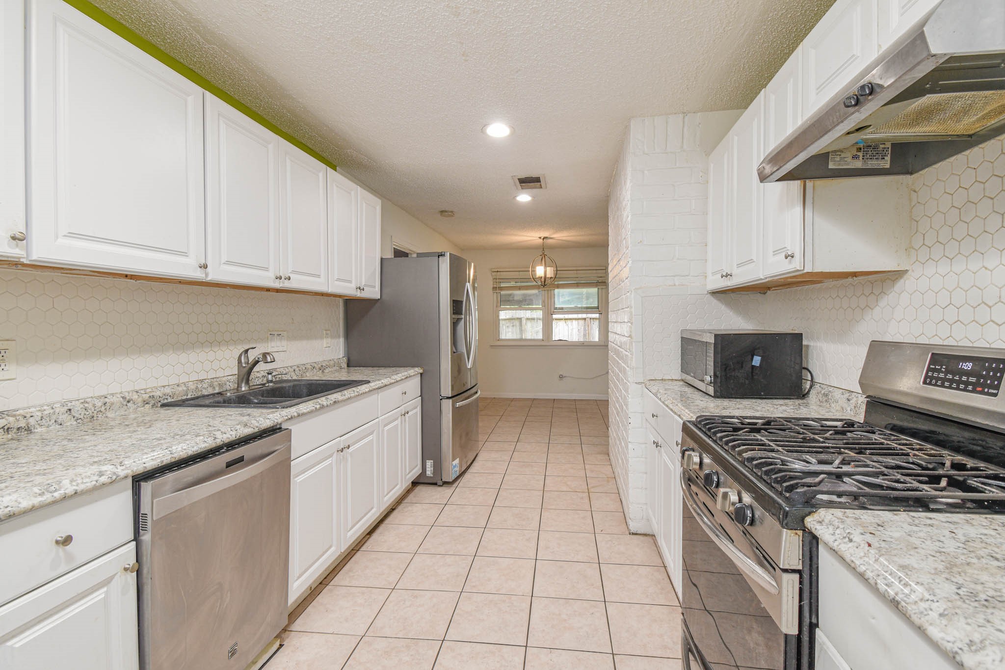 12054 Plumpoint Drive Houston, TX 77099 - Photo 9 of 24 a kitchen with stainless steel appliances granite countertop a stove a sink and a white cabinets
