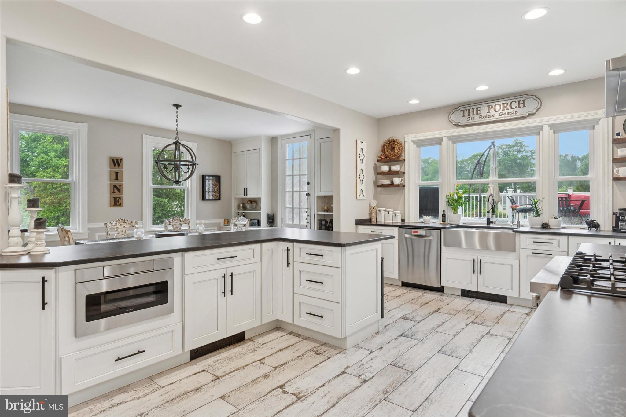 802 Upper Gulph Road Wayne, PA 19087 - Photo 15 of 45 a large white kitchen with a stove a sink dishwasher and white cabinets with wooden floor