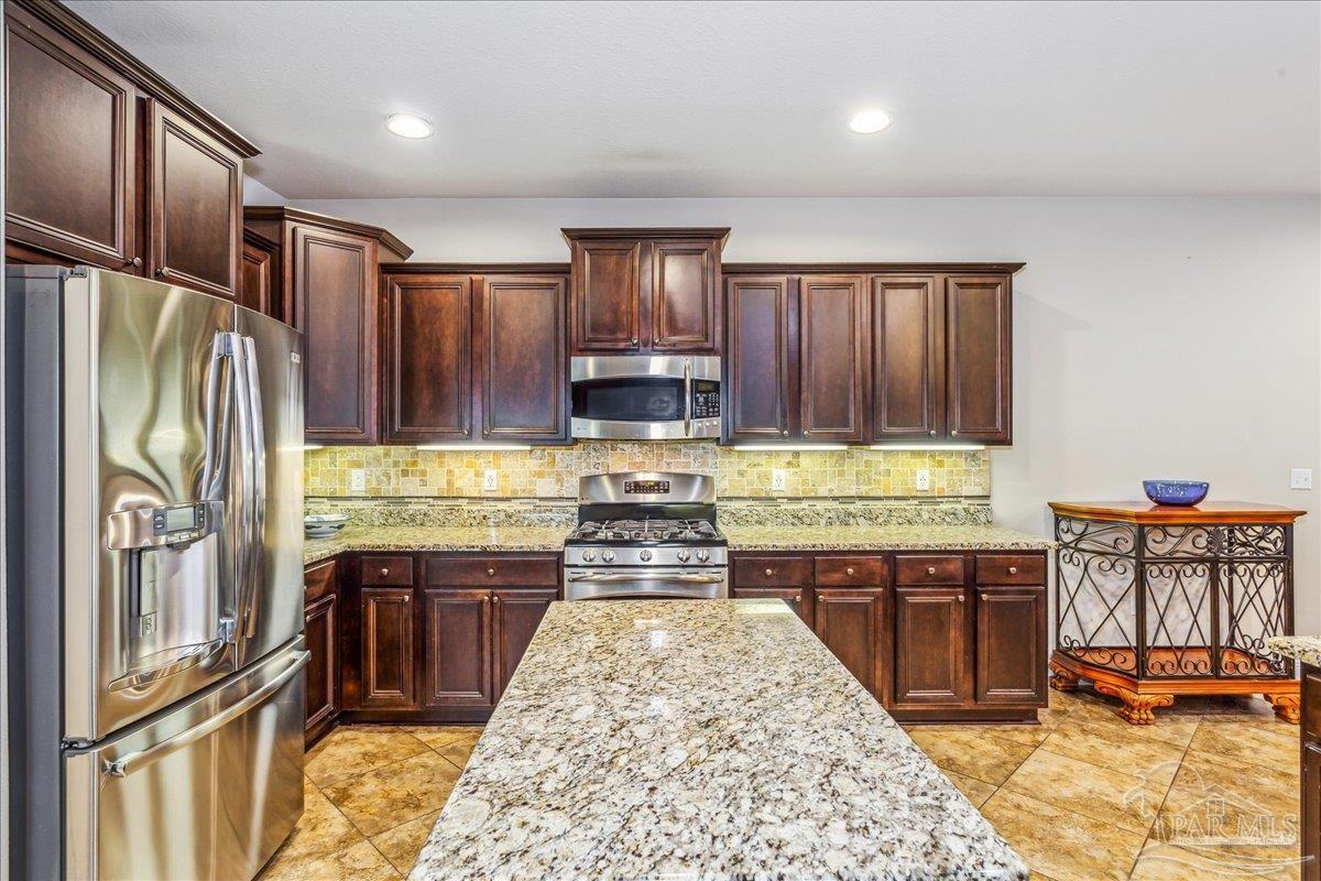 8414 Foxtail Loop Pensacola, FL 32526 - Photo 18 of 61 a kitchen with stainless steel appliances granite countertop a refrigerator a stove and a sink