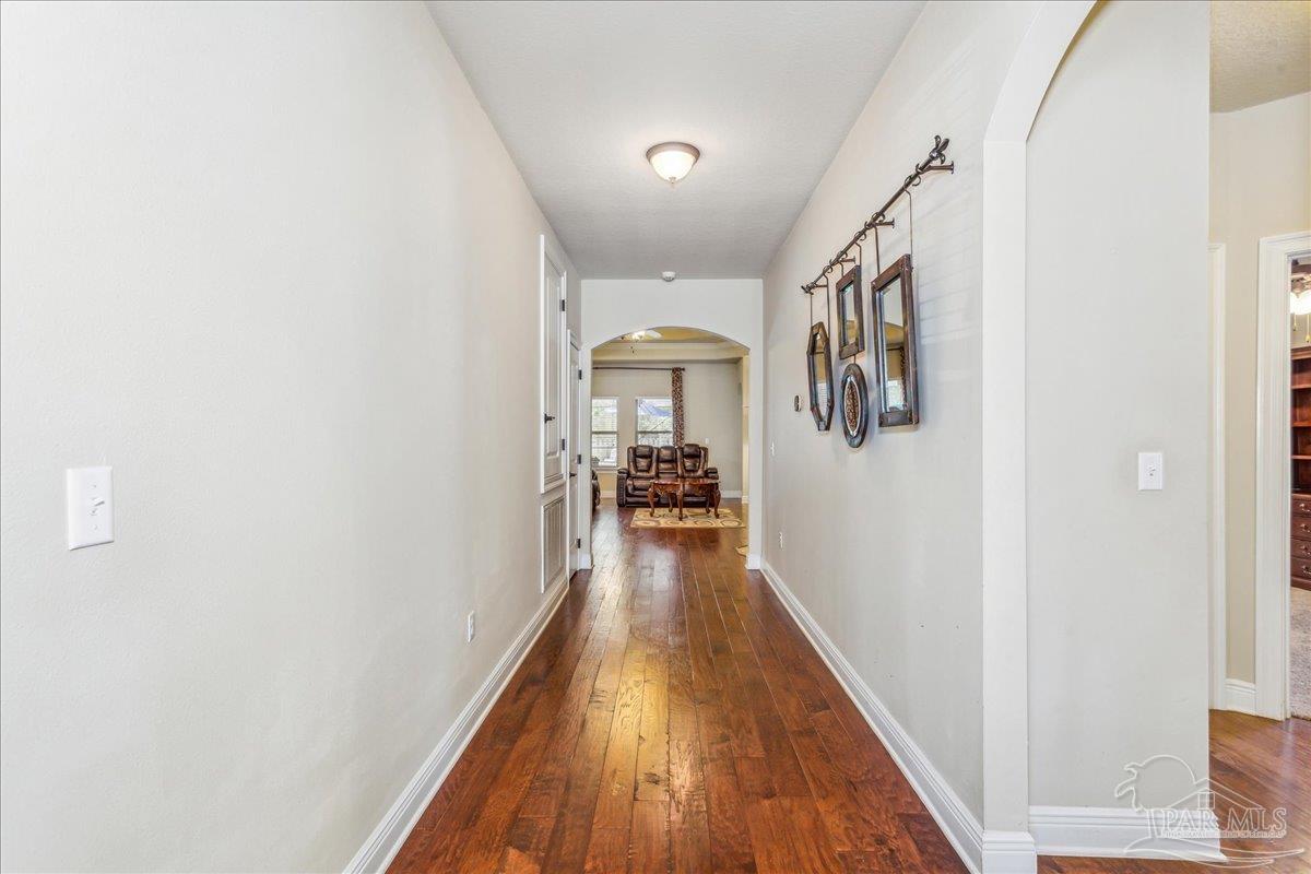 8414 Foxtail Loop Pensacola, FL 32526 - Photo 10 of 61 a view of a hallway with wooden floor and staircase
