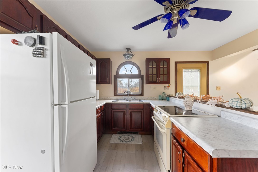 5511 Monroe Center Road Conneaut, OH 44030 - Photo 14 of 39 Kitchen featuring ceiling fan, sink, light wood-type flooring, and white appliances