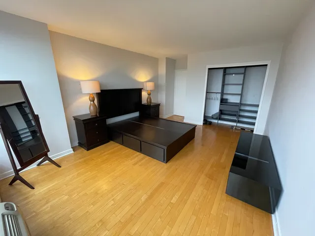 a bedroom with a bed and wooden floor