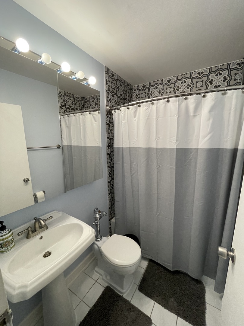 3900 North Lake Shore Drive, Unit 25C Chicago, IL 60613 - Photo 14 of 23 a bathroom with a sink and a mirror