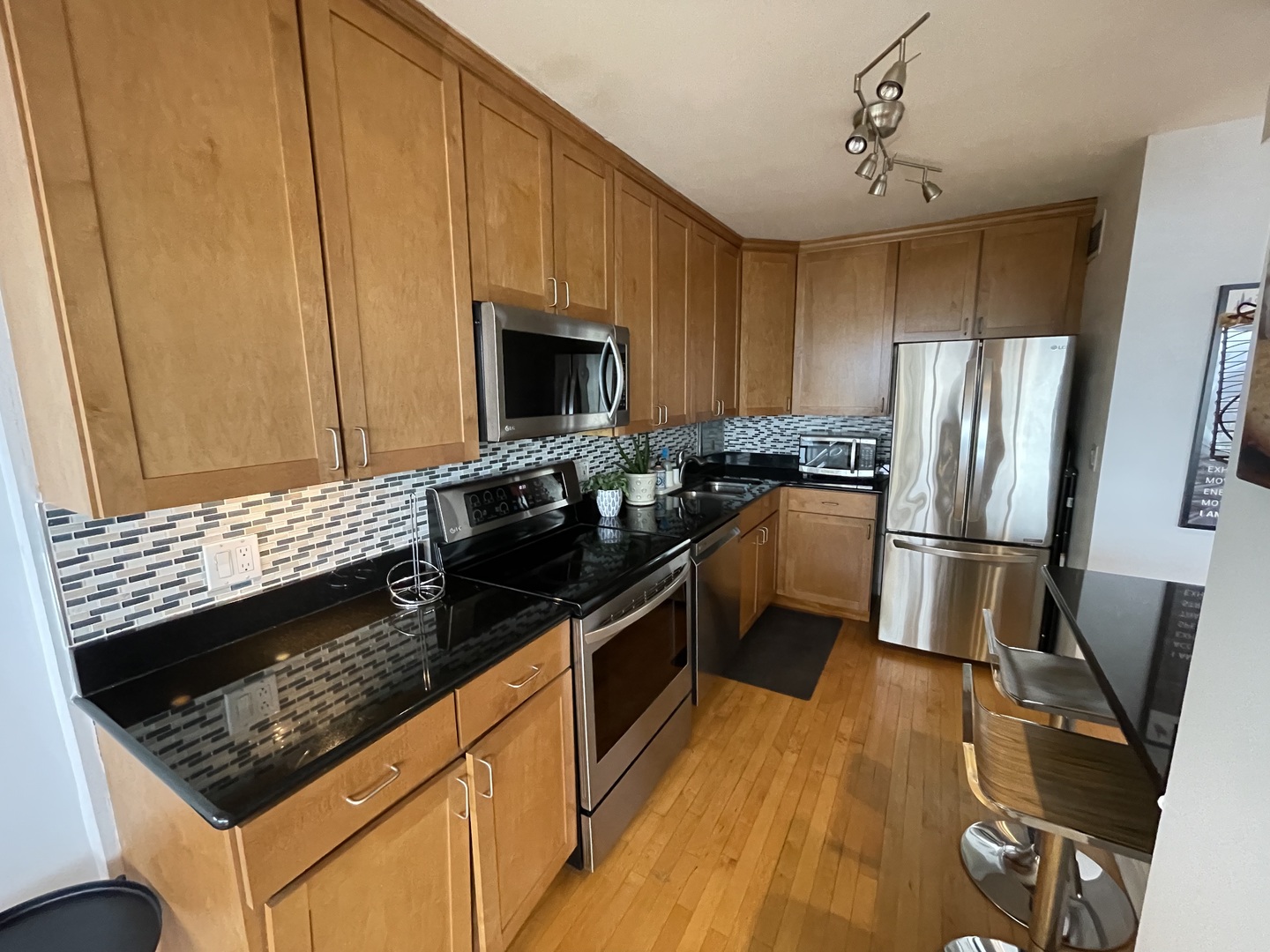 3900 North Lake Shore Drive, Unit 25C Chicago, IL 60613 - Photo 10 of 23 a kitchen with granite countertop stainless steel appliances a stove refrigerator sink and microwave