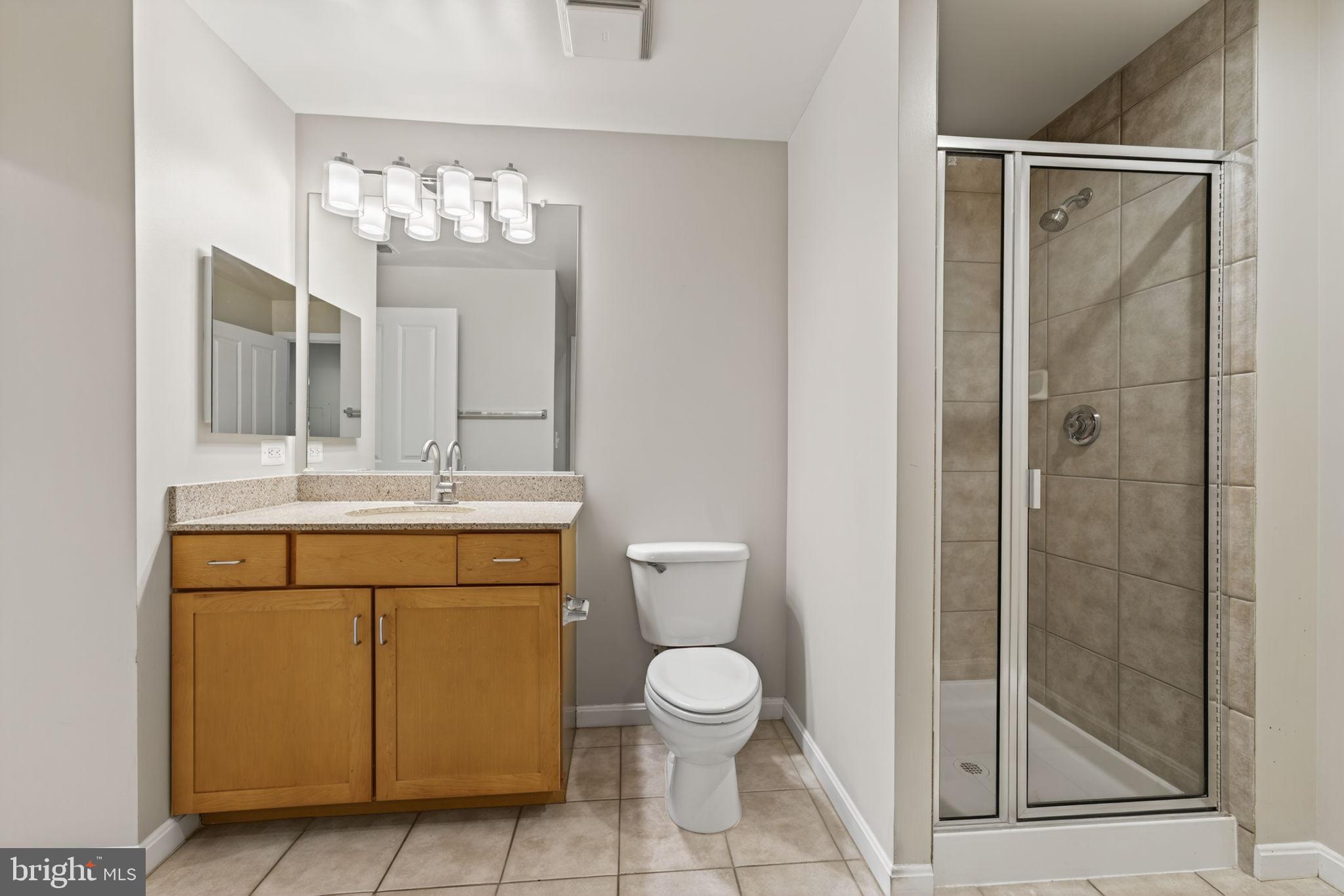 2220 Fairfax Drive, Unit 206 Arlington, VA 22201 - Photo 15 of 25 a bathroom with a toilet a sink and glass door