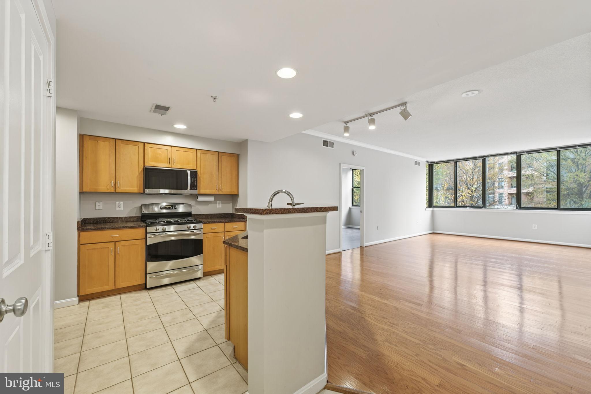 2220 Fairfax Drive, Unit 206 Arlington, VA 22201 - Photo 3 of 25 a kitchen with stainless steel appliances granite countertop a stove top oven a sink dishwasher and a refrigerator with wooden floor