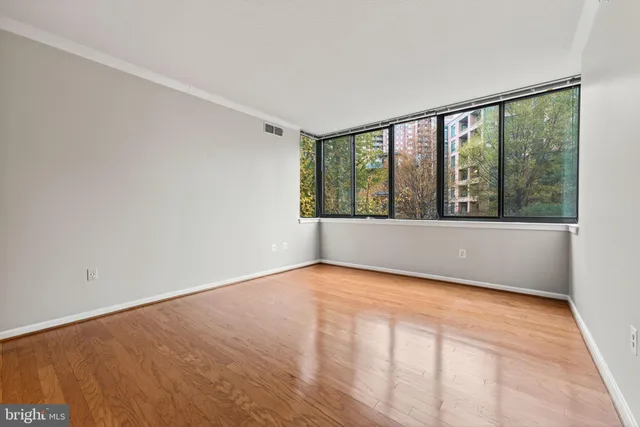 a view of empty room with wooden floor