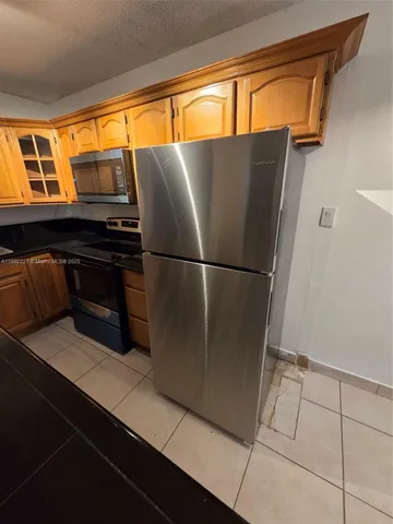 a kitchen with stainless steel appliances a refrigerator and a wooden floor