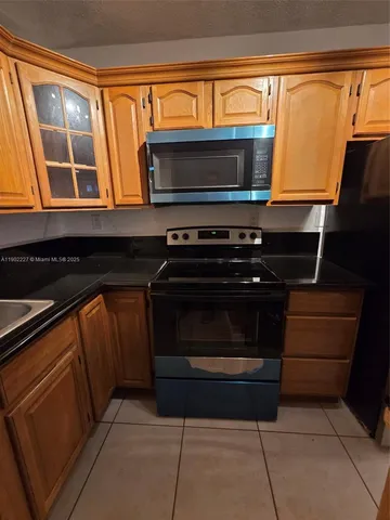 a kitchen with stainless steel appliances a stove and a microwave