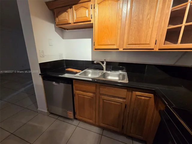 a kitchen with granite countertop cabinets sink and window