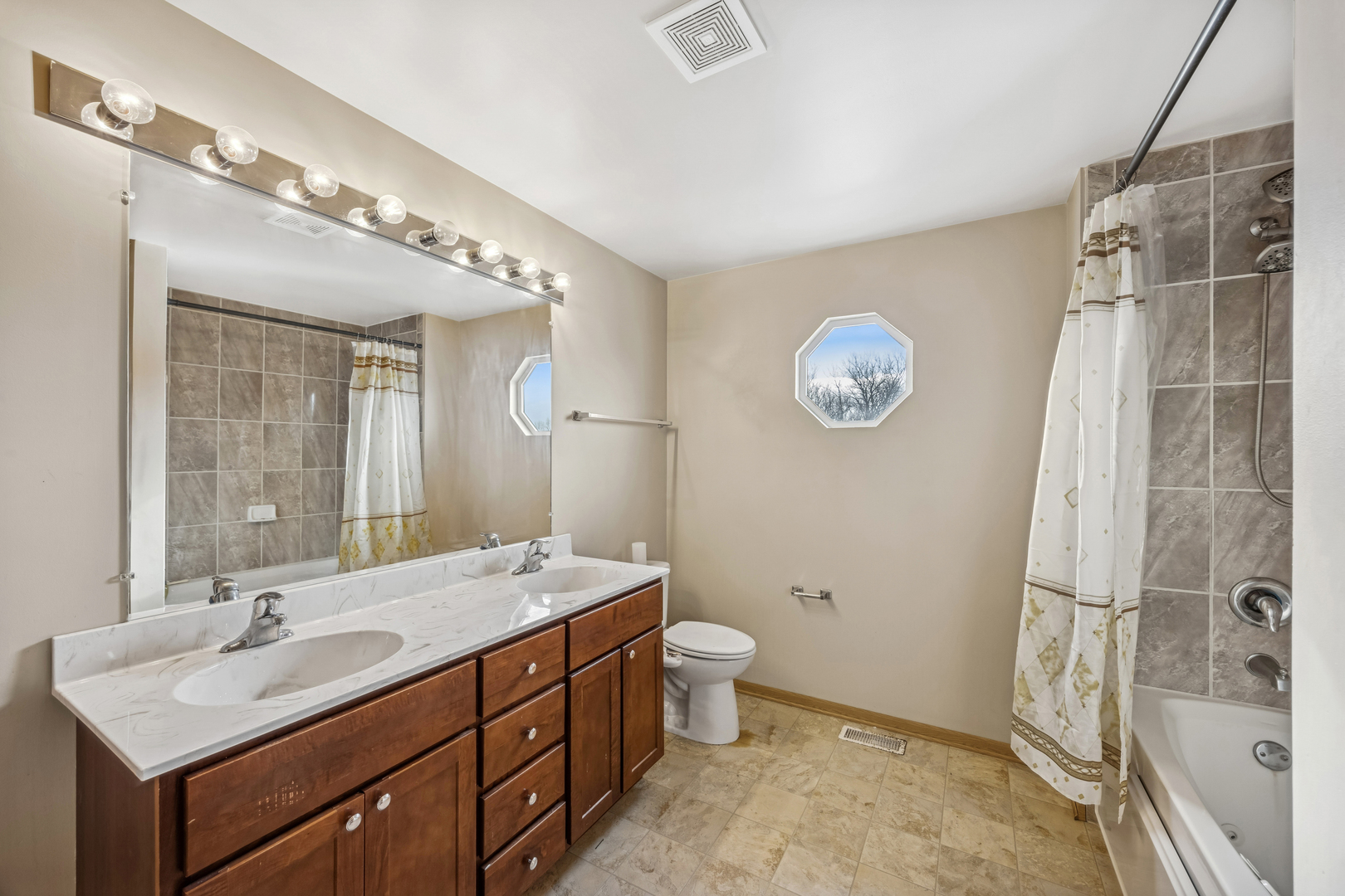14925 Whipple Street Markham, IL 60428 - Photo 11 of 16 a bathroom with a double vanity sink toilet and shower