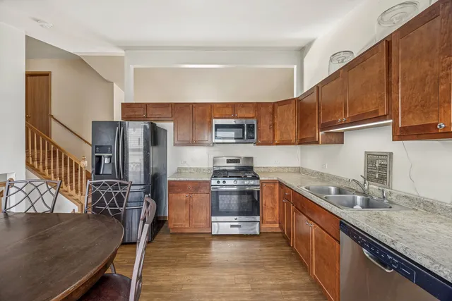 a kitchen with stainless steel appliances granite countertop a sink stove microwave and refrigerator