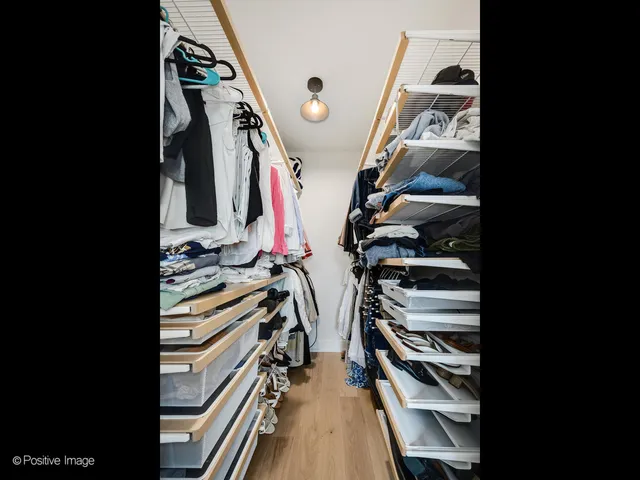 a view of walk in closet with clothes