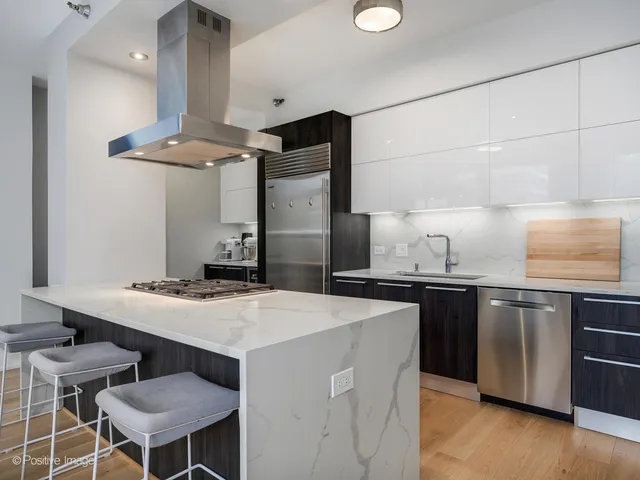 a kitchen with stainless steel appliances granite countertop a sink a stove a refrigerator and island