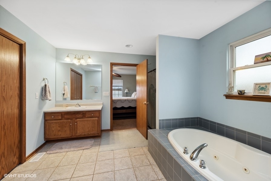 W6530 Barkers Road Elkhorn, WI 53121 - Photo 12 of 19 a spacious bathroom with a tub sink and mirror