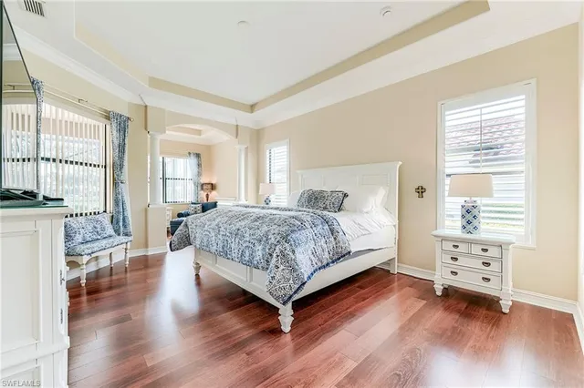 a bedroom with a bed and wooden floor