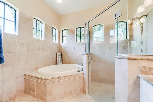 a bathroom with a tub a sink and a mirror