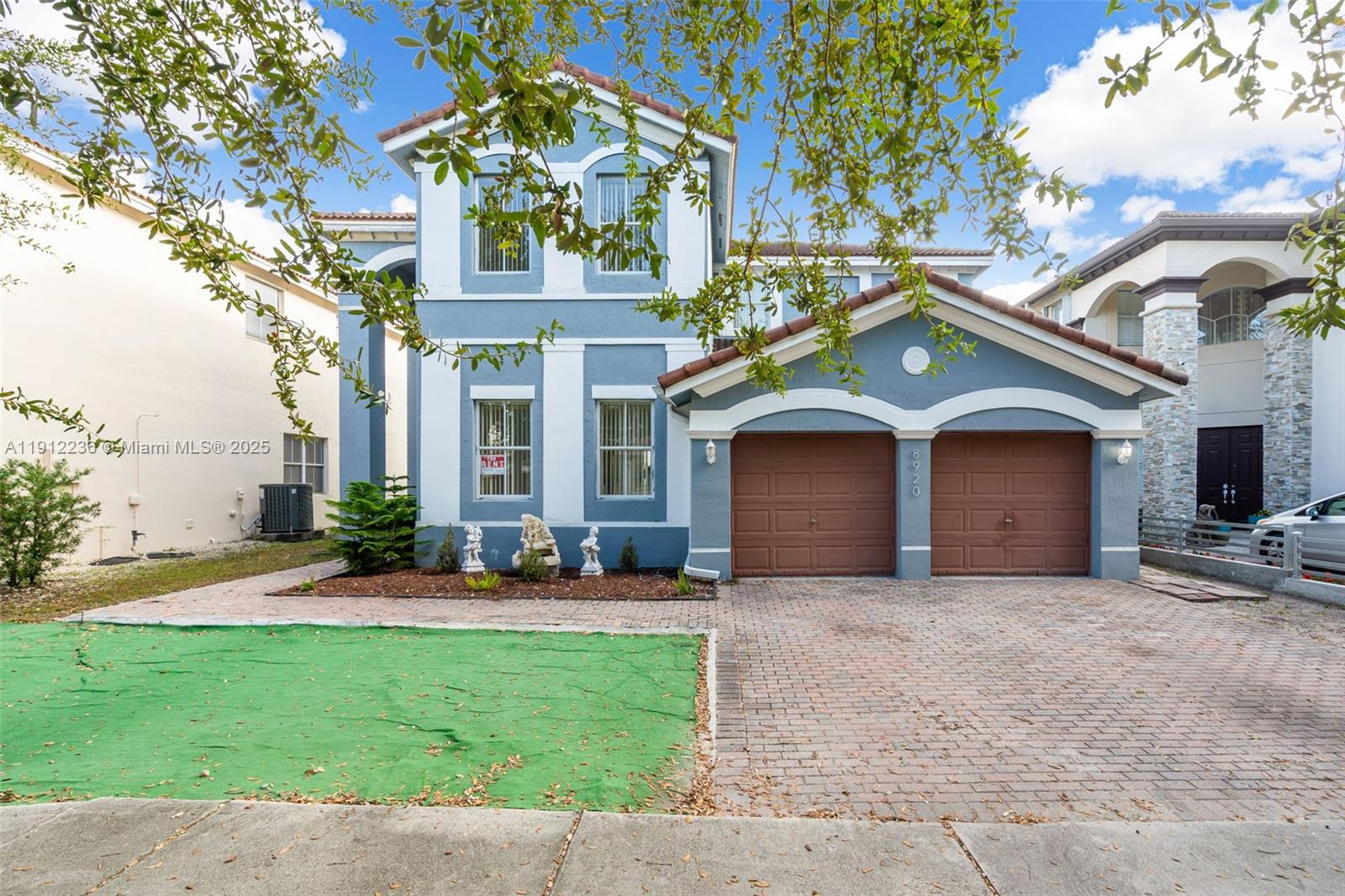 8920 Northwest 180th Terrace Hialeah, FL 33018 - Photo 1 of 44 a view of a brick house with a yard and large tree