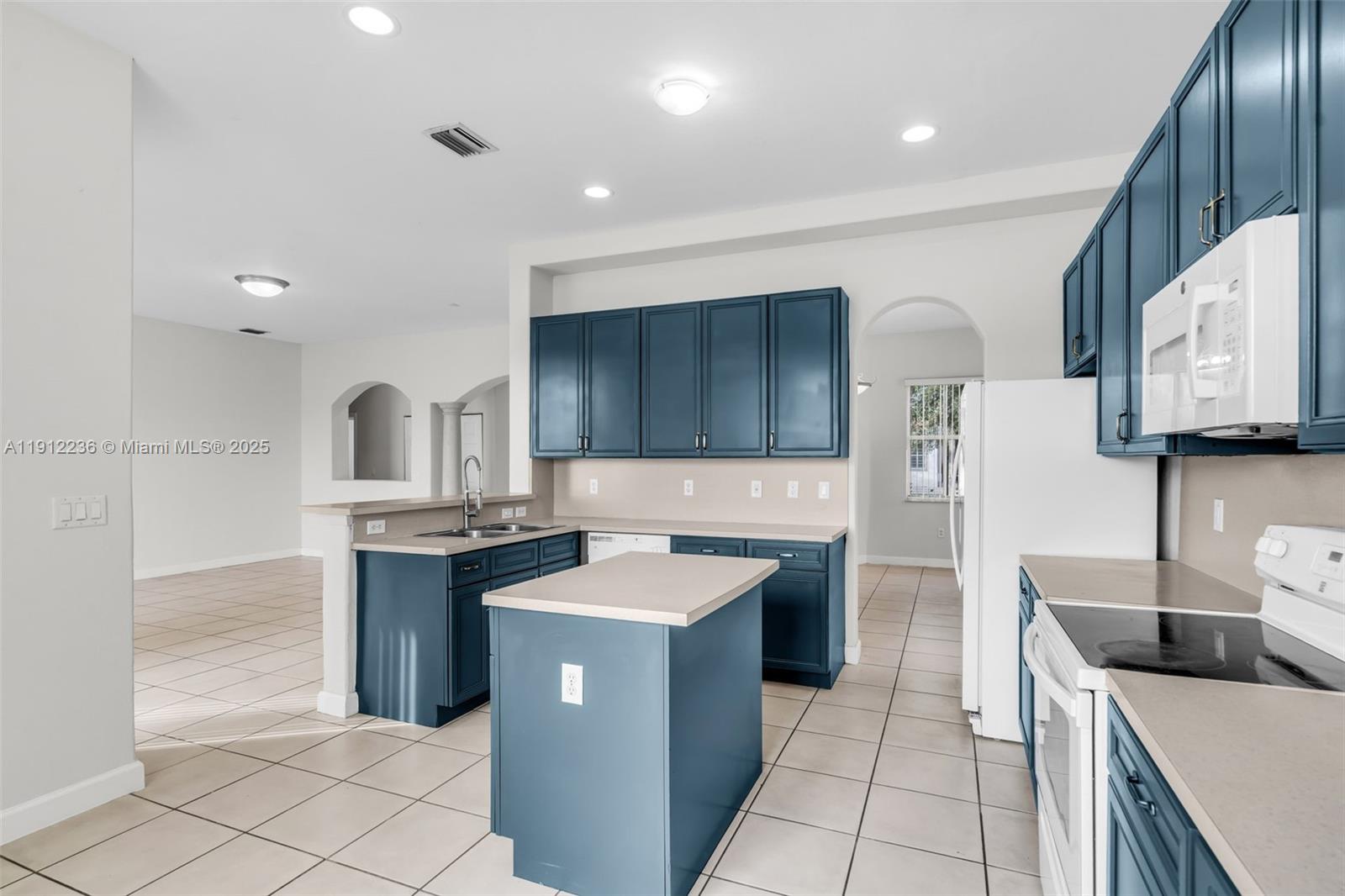 8920 Northwest 180th Terrace Hialeah, FL 33018 - Photo 13 of 44 a kitchen with stainless steel appliances granite countertop a sink stove and refrigerator