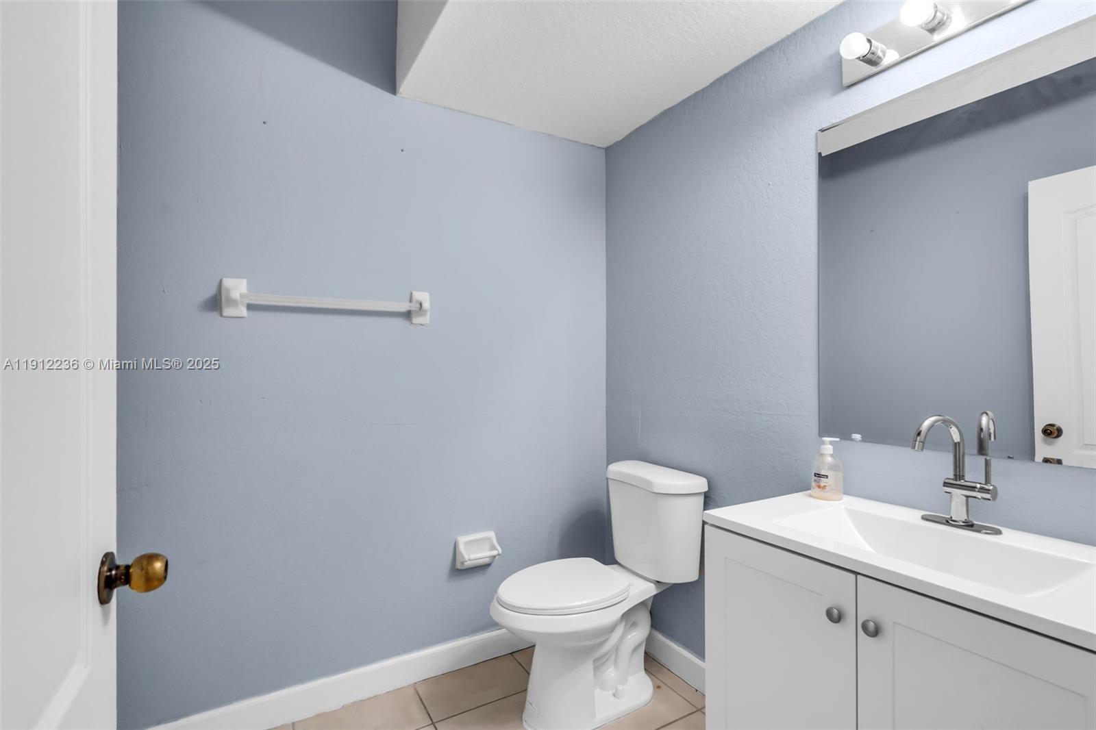 8920 Northwest 180th Terrace Hialeah, FL 33018 - Photo 19 of 44 a bathroom with a toilet sink and mirror