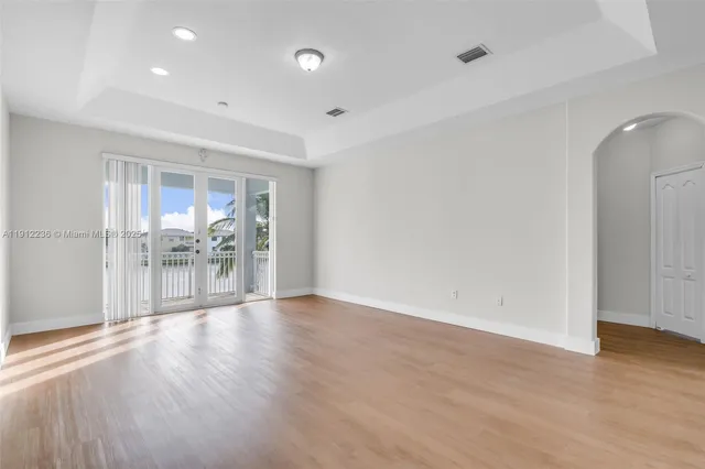 a view of empty room with wooden floor and window