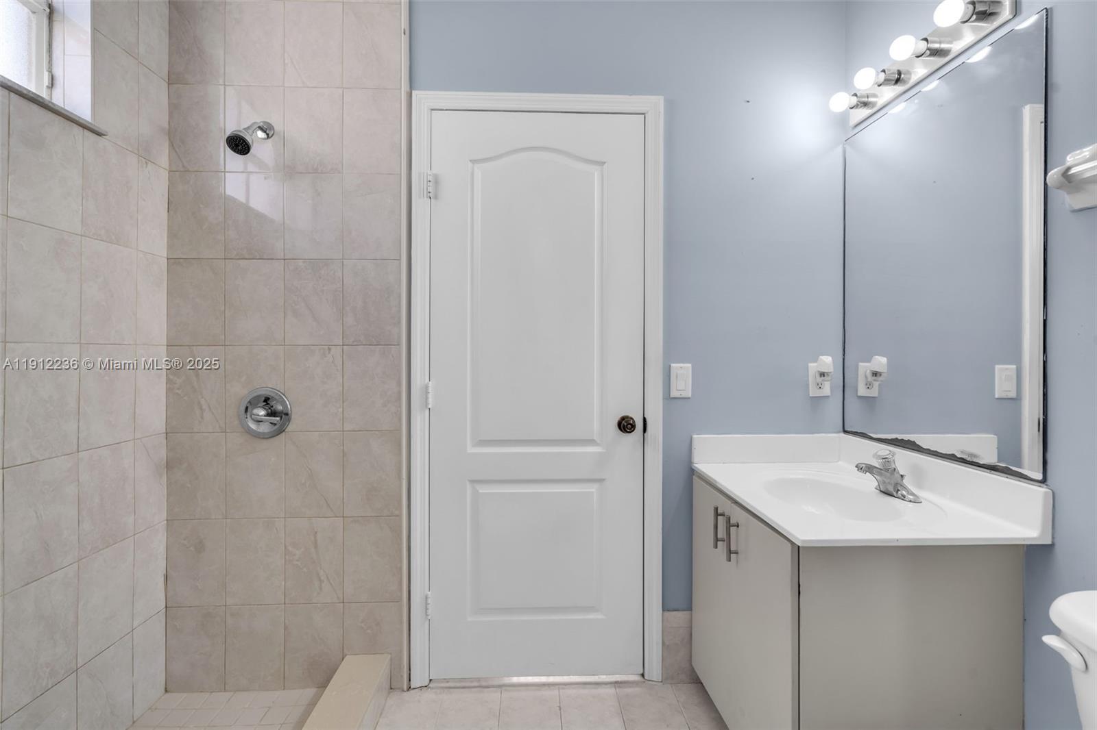 8920 Northwest 180th Terrace Hialeah, FL 33018 - Photo 31 of 44 a bathroom with a sink and mirror