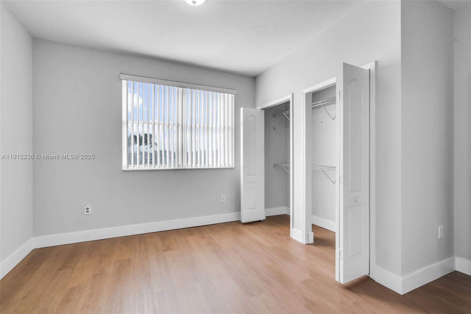 8920 Northwest 180th Terrace Hialeah, FL 33018 - Photo 34 of 44 an empty room with wooden floor and windows