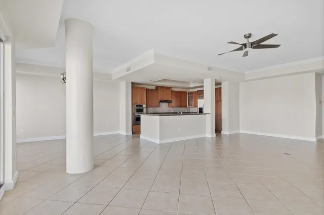 a view of a hallway with kitchen and chandelier