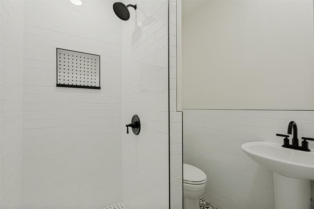 4316 Springbranch Drive Benbrook, TX 76116 - Photo 22 of 39 Shower enclosure featuring subway tile walls, a built-in niche, and matte black fixtures