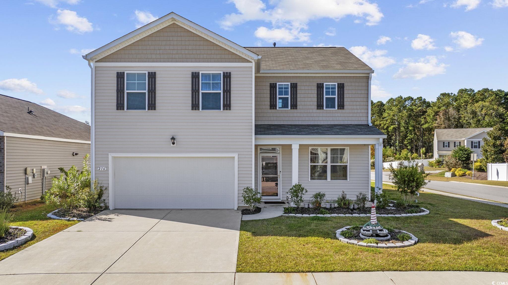 View of front of property with a front yard, a porch, concrete driveway, an attached garage, and a shingled roof