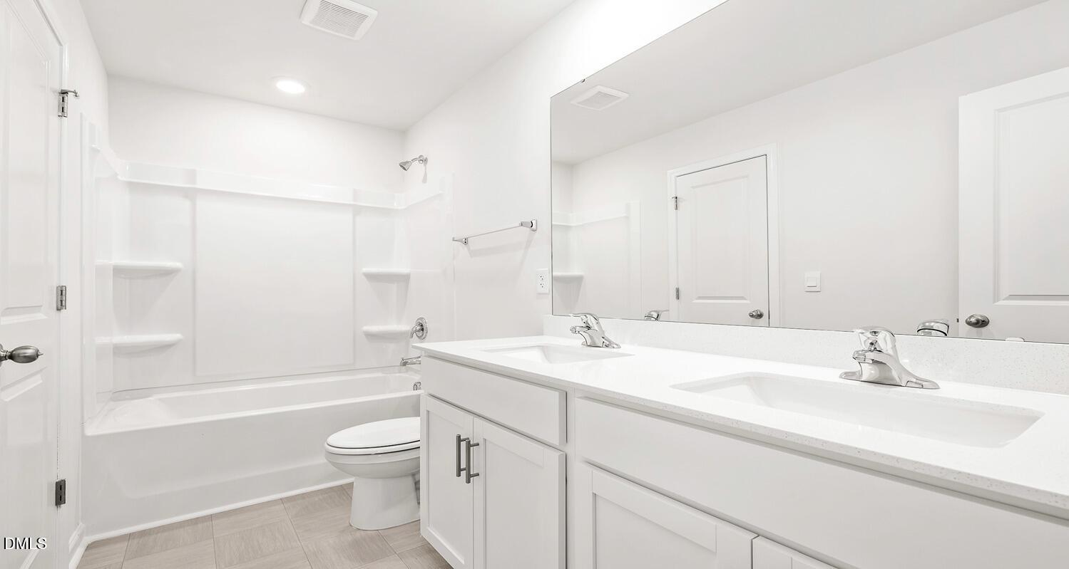 1383 Lansdowne Drive, Unit 401 Mebane, NC 27302 - Photo 20 of 23 a bathroom with a sink a toilet and shower