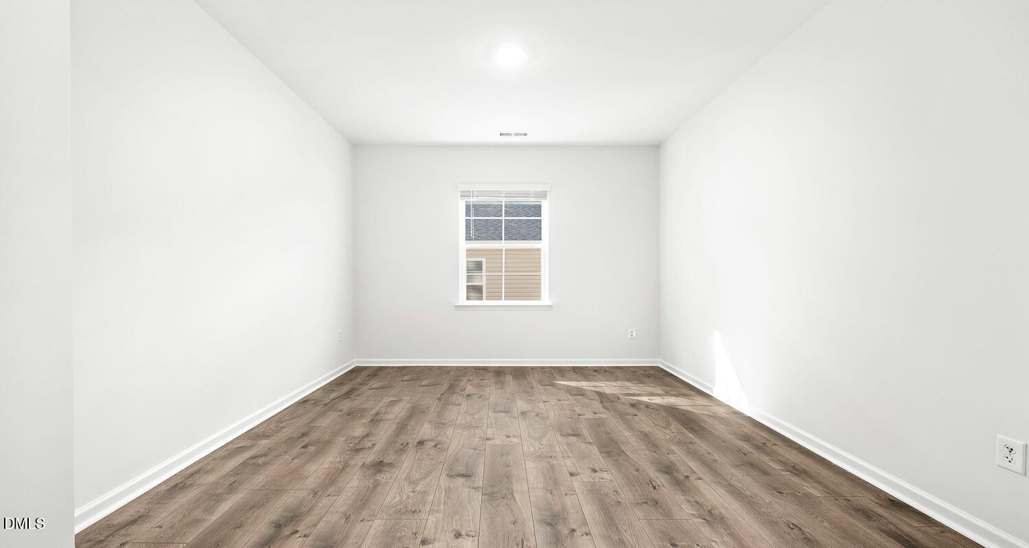 1383 Lansdowne Drive, Unit 401 Mebane, NC 27302 - Photo 4 of 23 an empty room with wooden floor and windows
