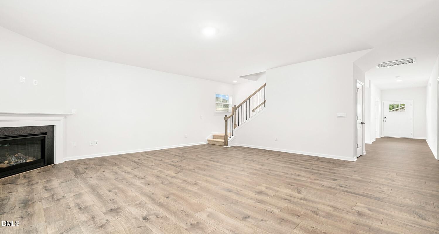 1383 Lansdowne Drive, Unit 401 Mebane, NC 27302 - Photo 9 of 23 a view of empty room with wooden floor and fireplace