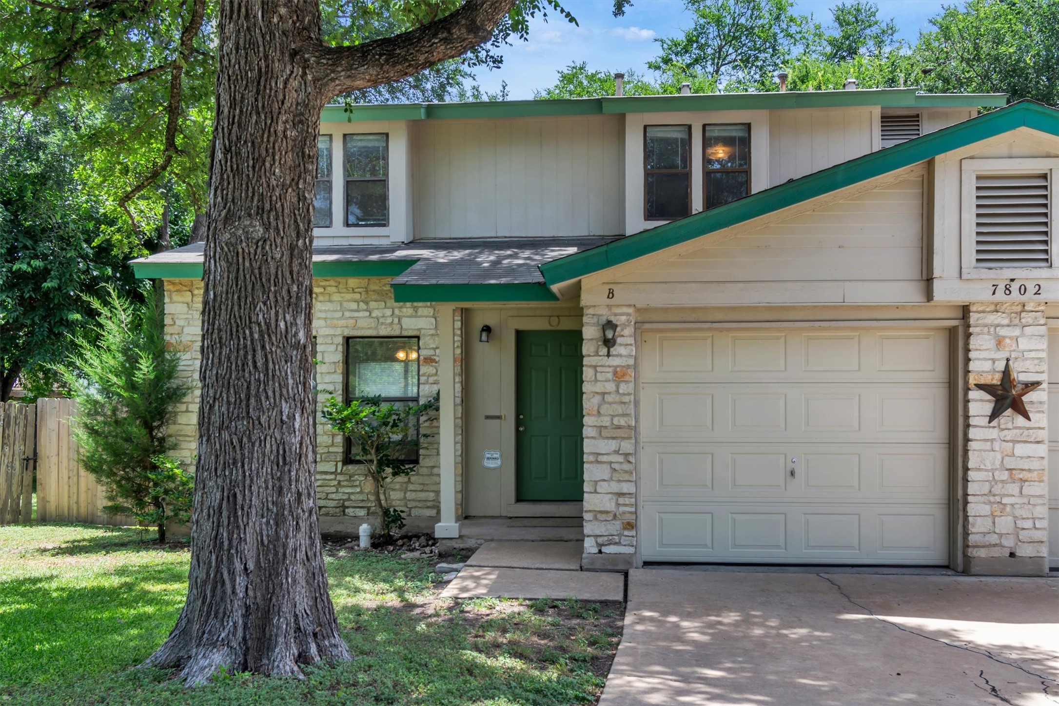 7802 Topawa Cove, Unit B Austin, TX 78729 - Photo 1 of 32 A welcoming stone and siding facade offers excellent curb appeal and a two-car garage.